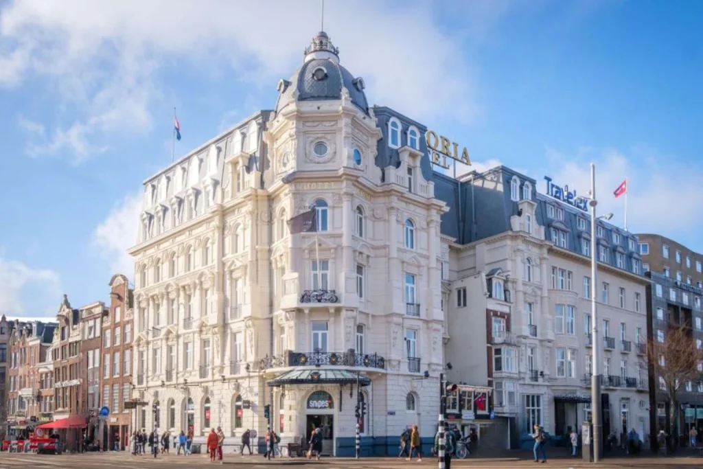 Grand historic hotel building with ornate architecture on a busy city street at Park Plaza Victoria Amsterdam, Amsterdam