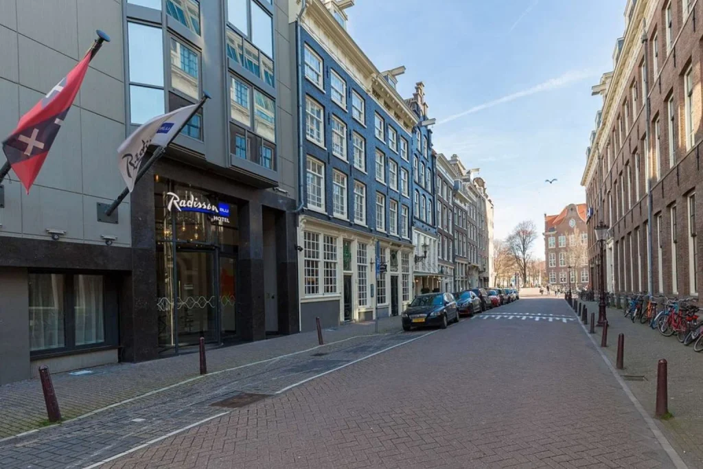 Quiet city-centre street lined with traditional Dutch architecture beside Radisson Blu Hotel, Amsterdam City Center, Amsterdam, Netherlands