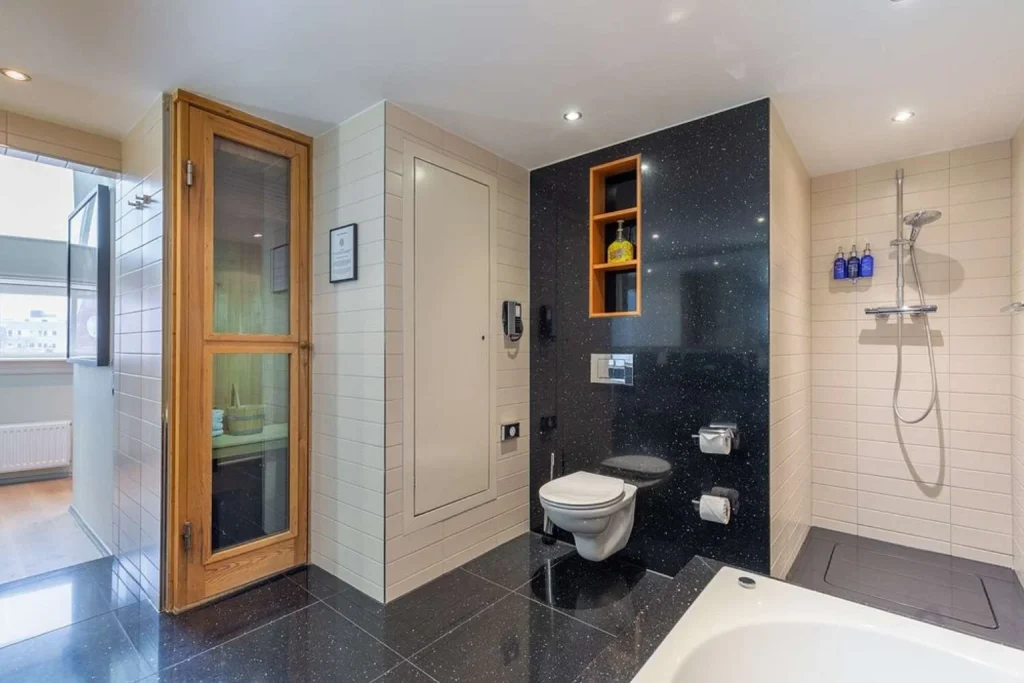 Spacious modern bathroom with a private sauna, bathtub and walk-in shower at Radisson Blu Hotel Amsterdam.