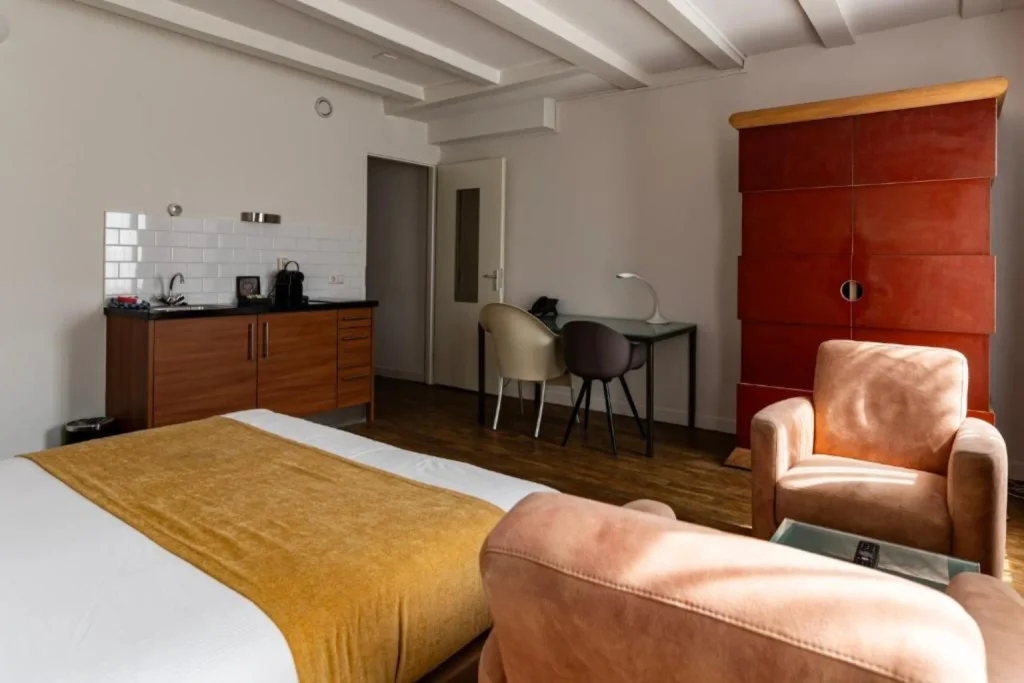 Spacious studio with a double bed, private kitchenette, dining space and comfortable seating area at Residence Le Coin, Amsterdam.
