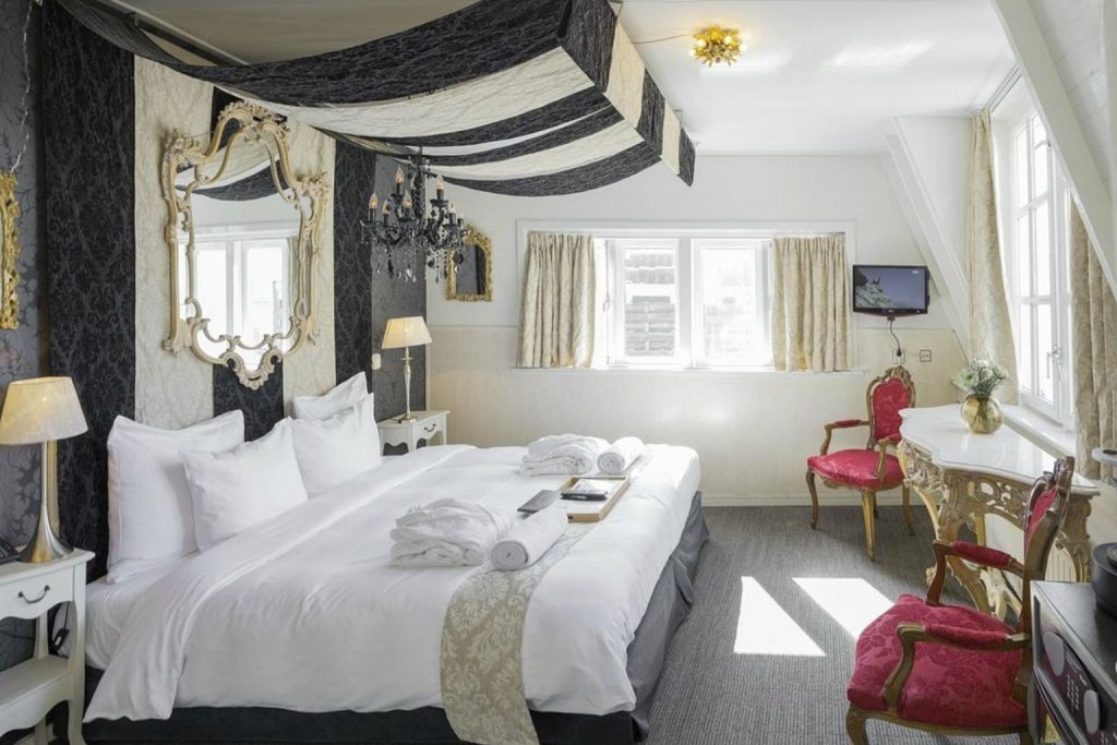Elegant bedroom with seating area at Rosalia’s InnUpstairs