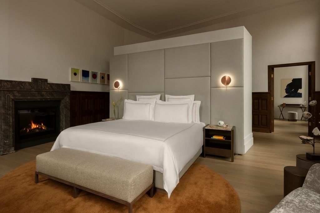 Elegant luxury bedroom with king bed, fireplace and contemporary furnishings at Rosewood Amsterdam