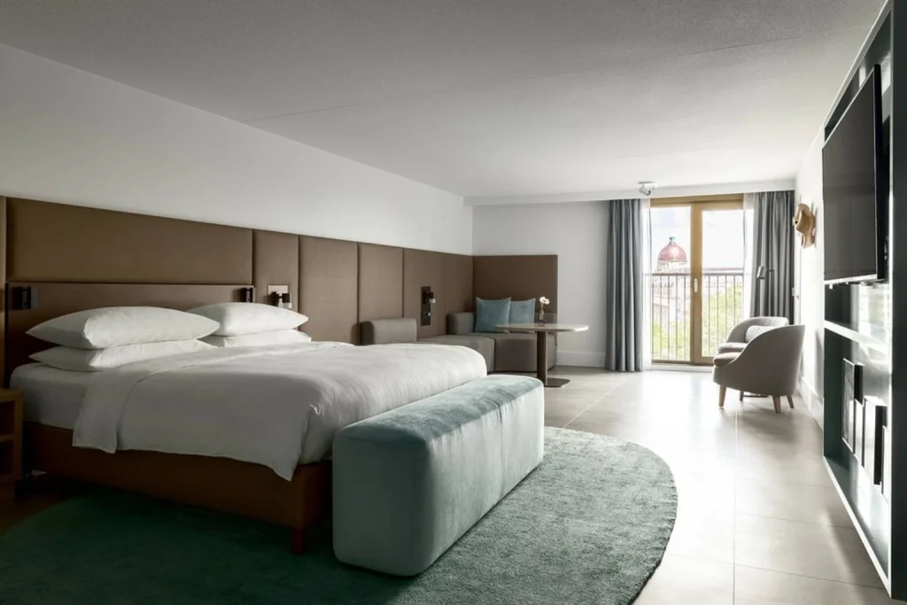 Spacious modern guest room with king-size bed, seating area and large windows at Amsterdam Marriott Hotel, Amsterdam
