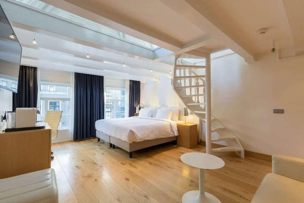 Spacious modern guest room with wooden floors, interior staircase and skylight at Radisson Blu Hotel, Amsterdam City Center, Amsterdam