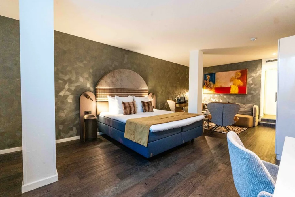 Contemporary guest room with a king bed, stylish seating area, dark wood flooring and modern artwork, The Albus Hotel Amsterdam