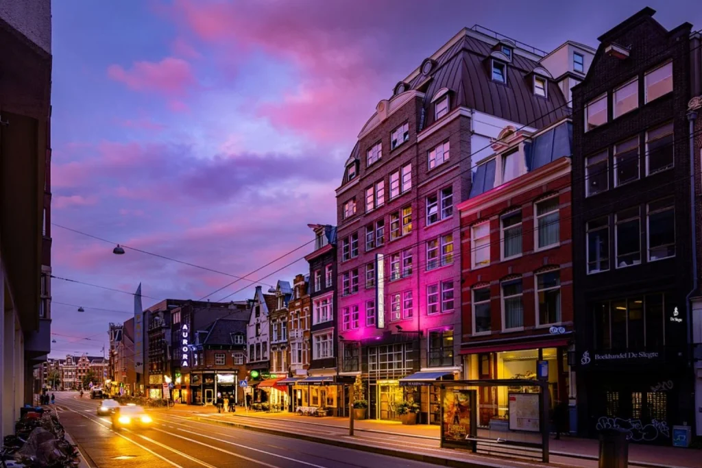 Colorful evening cityscape with historic buildings and lively streets at The Albus Boutique Hotel Amsterdam.