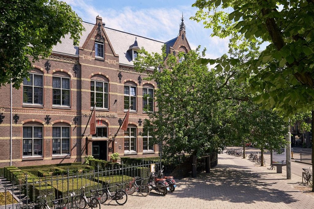 Grand historic brick façade set among mature trees in Amsterdam’s Museum Quarter, The College Hotel, Amsterdam
