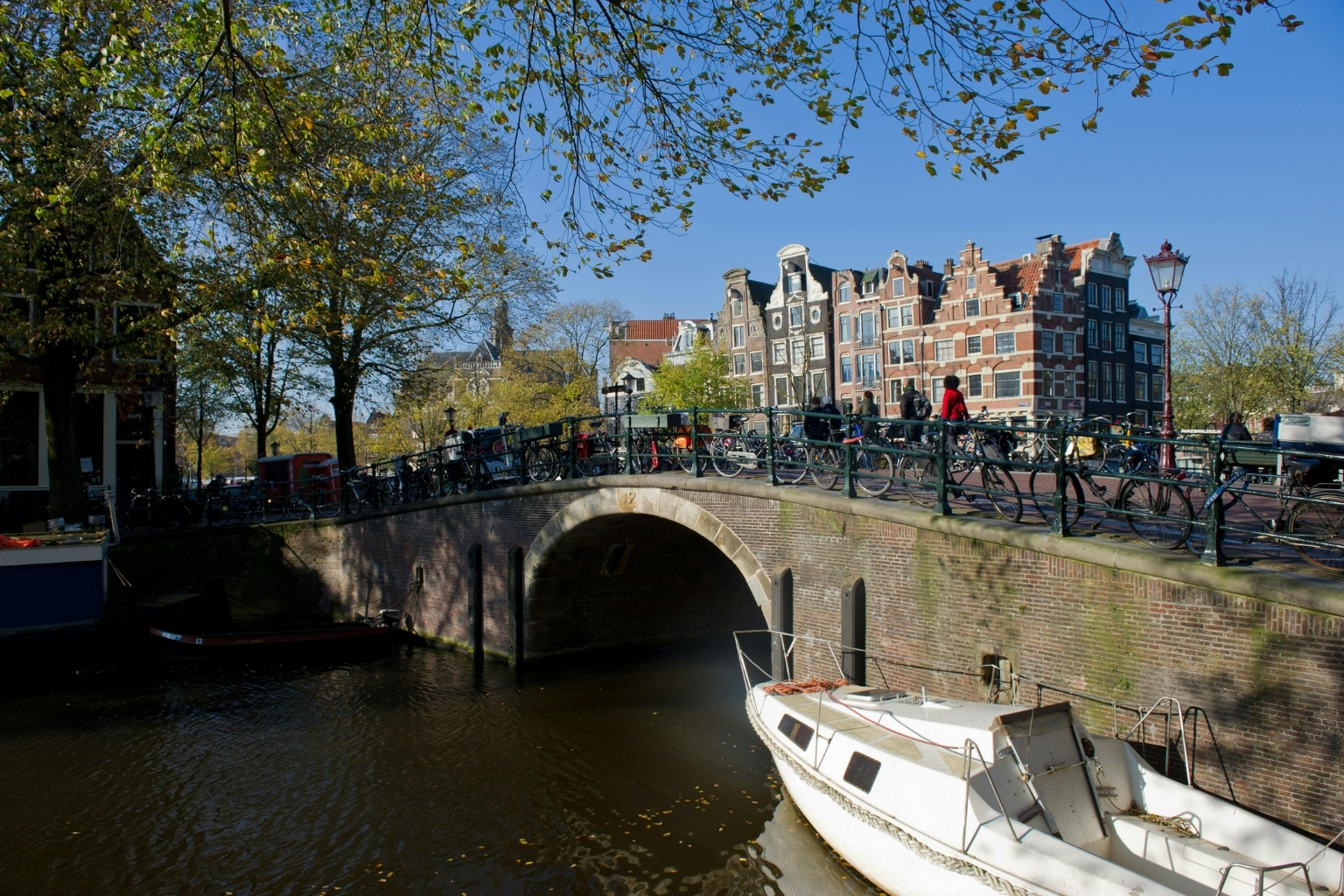 View from a guest room overlooking an Amsterdam canal, bridge, boats and historic canal houses, The Green Canal House, Amsterdam