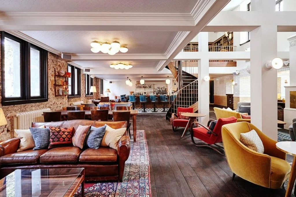 Stylish lounge at The Hoxton Amsterdam, featuring vintage furnishings, warm tones and a relaxed boutique atmosphere.