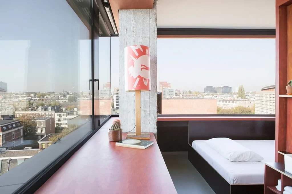 Room with panoramic city views and modern interior at Volkshotel Amsterdam