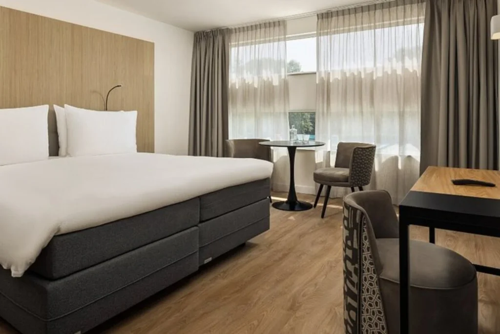 Contemporary double room with a spacious bed, seating area and work desk at WestCord Art Hotel Amsterdam.