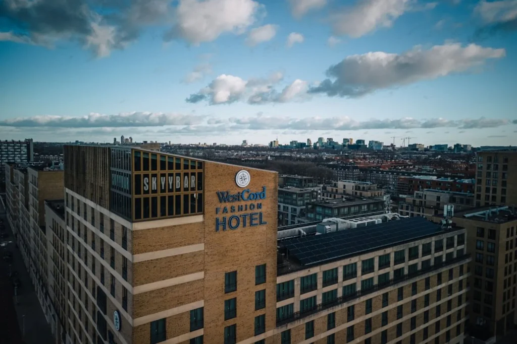 Elevated city view featuring the hotel building and Amsterdam skyline beneath a dramatic sky at WestCord Fashion Hotel Amsterdam, Amsterdam, Netherlands