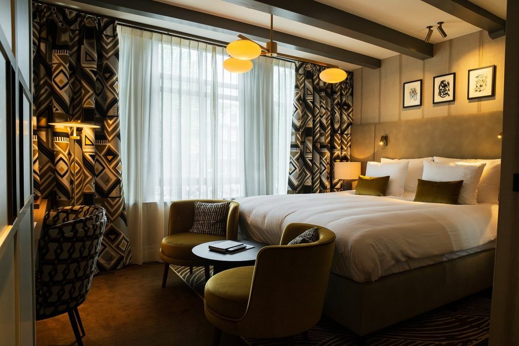 Luxury boutique hotel room with king-size bed, designer lighting and stylish seating area at Ambassade Hotel in Amsterdam