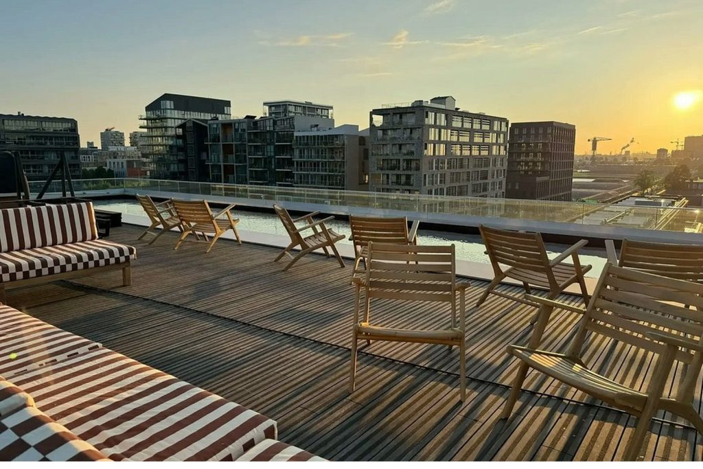 Rooftop terrace with outdoor seating and sunset views across Amsterdam at Bob W Amsterdam Noord