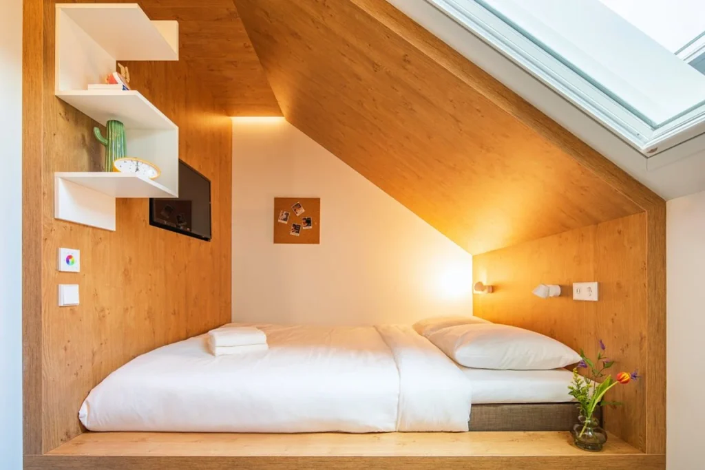 Contemporary hostel sleeping pods with individual beds and privacy curtains at BUNK Amsterdam, Amsterdam, Netherlands