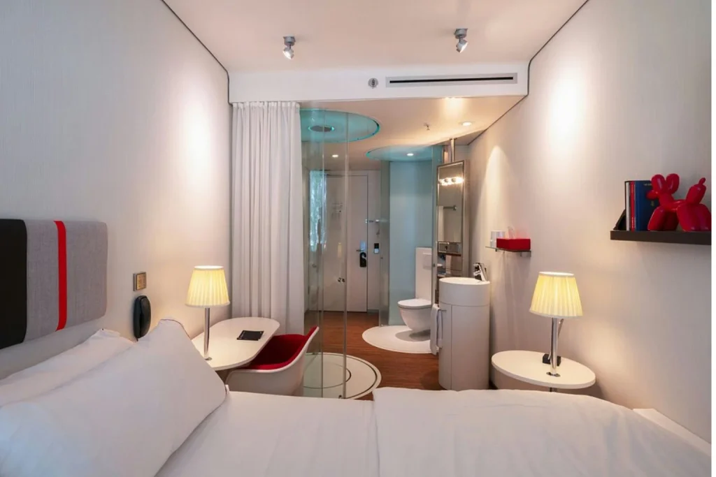 Modern compact hotel room with contemporary design and glass bathroom at citizenM Amsterdam South, Amsterdam