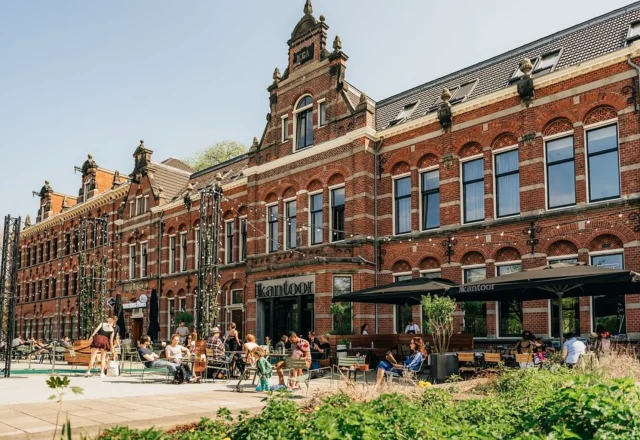 Historic brick hotel building with outdoor terrace and greenery at Conscious Hotel Westerpark, Amsterdam