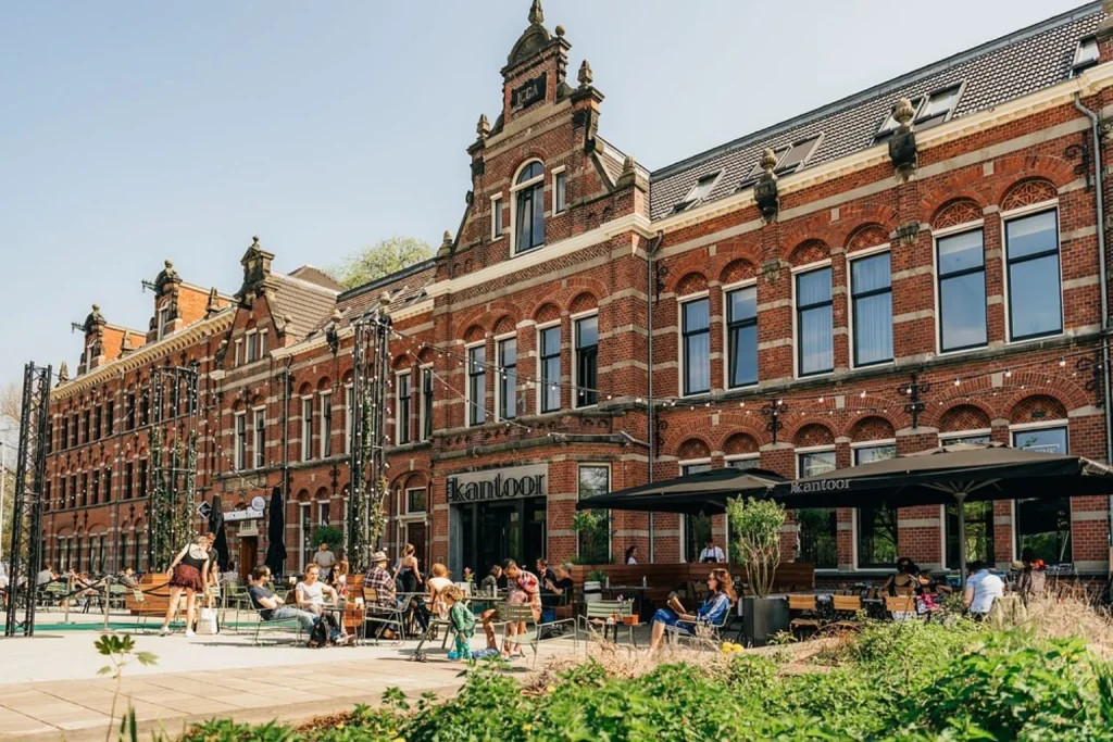 Historic brick hotel building with outdoor terrace and greenery at Conscious Hotel Westerpark, Amsterdam