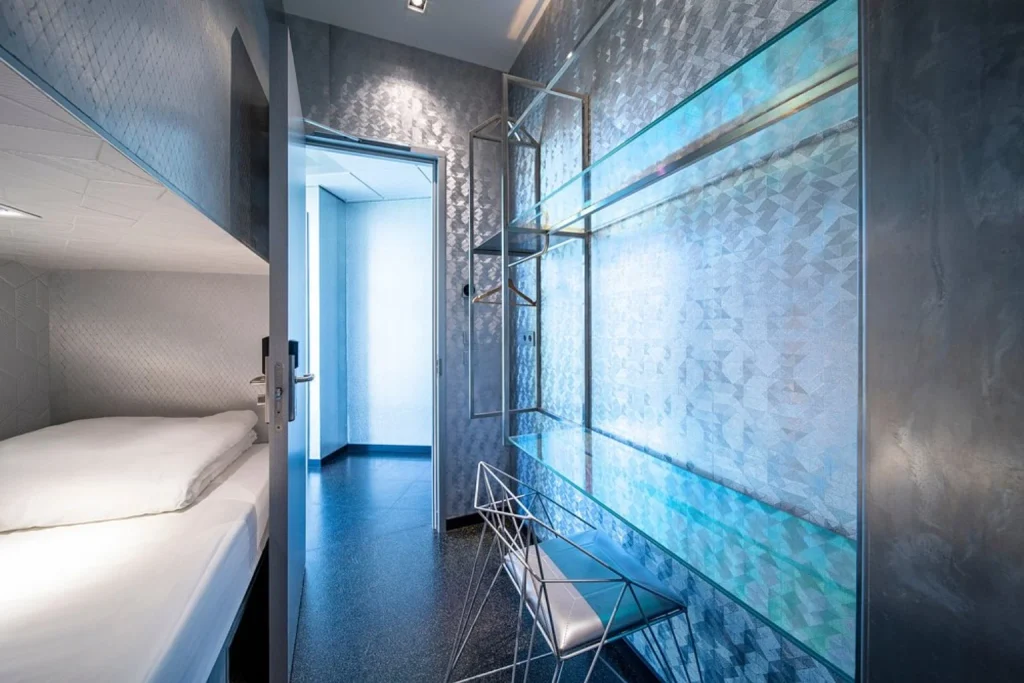 Sleek compact guest room with contemporary design and blue ambient lighting at Diamond Capsule Hotel Amsterdam South, Amsterdam, Netherlands