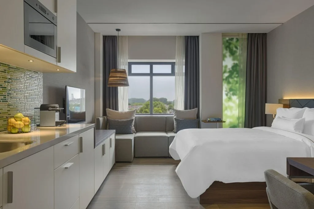 Modern studio hotel room with king-size bed and fully equipped kitchenette at Element Amsterdam, Amsterdam