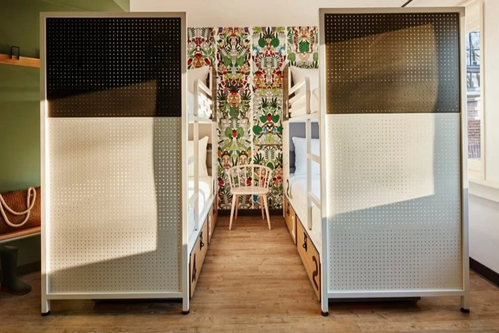 Stylish shared room with bunk beds, privacy screens and contemporary interior design at Generator Amsterdam, Amsterdam, Netherlands