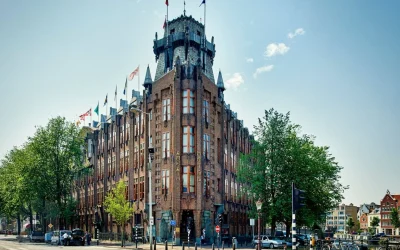 Landmark historic hotel featuring an imposing brick façade, distinctive tower and ornate architectural details near Amsterdam’s waterfront, Grand Hotel Amrâth Amsterdam, Amsterdam.