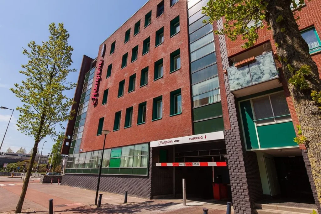 Modern red-brick hotel building with contemporary architecture and a street-side entrance at Hampton by Hilton Amsterdam Centre East.