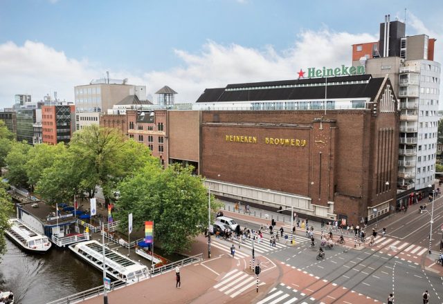 Historic Heineken brewery building beside the canal and busy city streets at Heineken Experience, Amsterdam