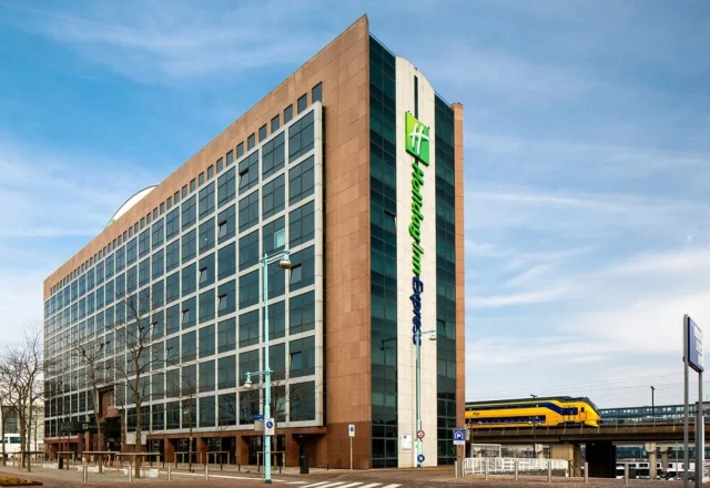 Modern hotel exterior beside the railway tracks and station at Holiday Inn Express Amsterdam – Sloterdijk Station, Amsterdam