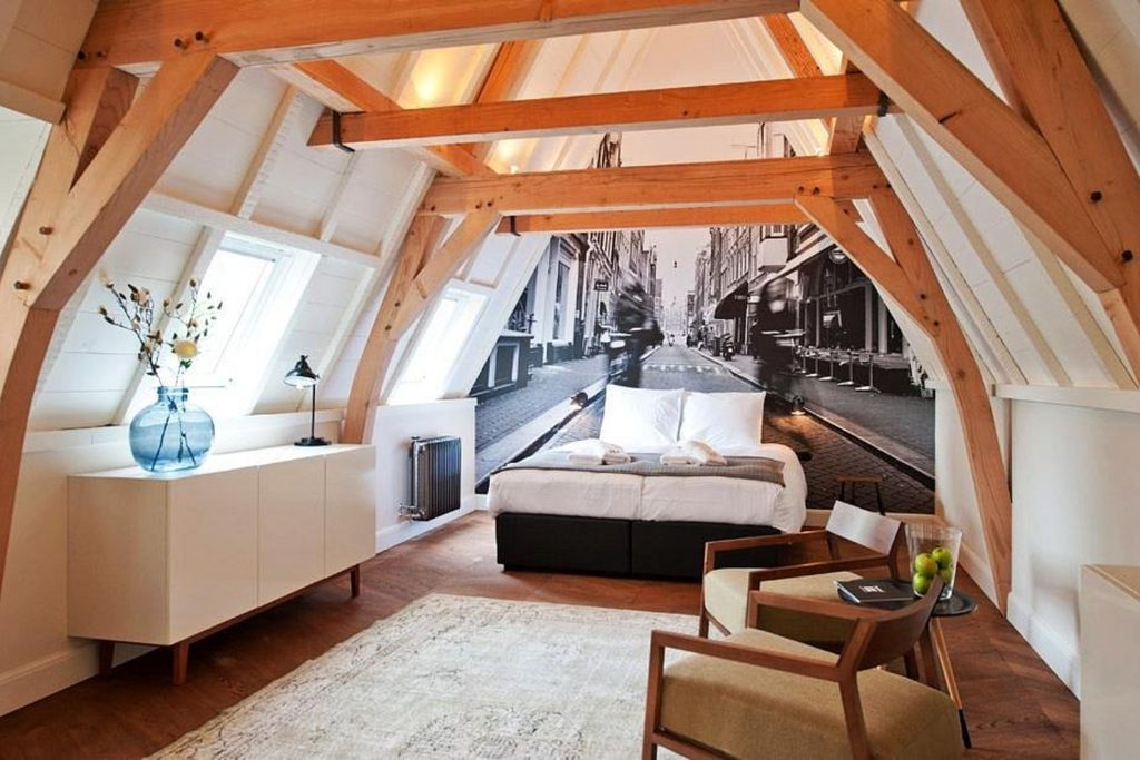 Bright attic-style room combining exposed timber beams, contemporary furnishings and distinctive Amsterdam-inspired décor at Hotel IX Nine Streets, Amsterdam