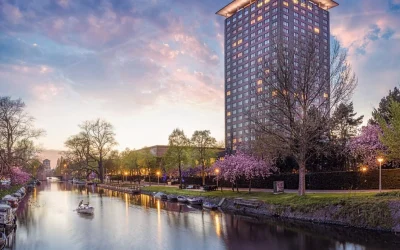 Luxury hotel tower overlooking a scenic canal at Hotel Okura Amsterdam, Amsterdam