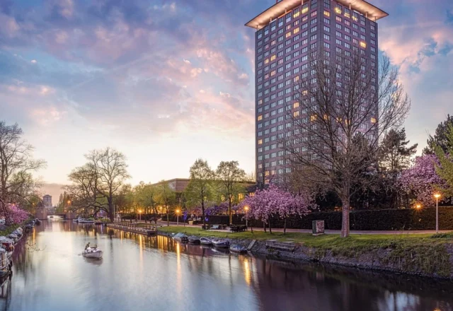 Luxury hotel tower overlooking a scenic canal at Hotel Okura Amsterdam, Amsterdam