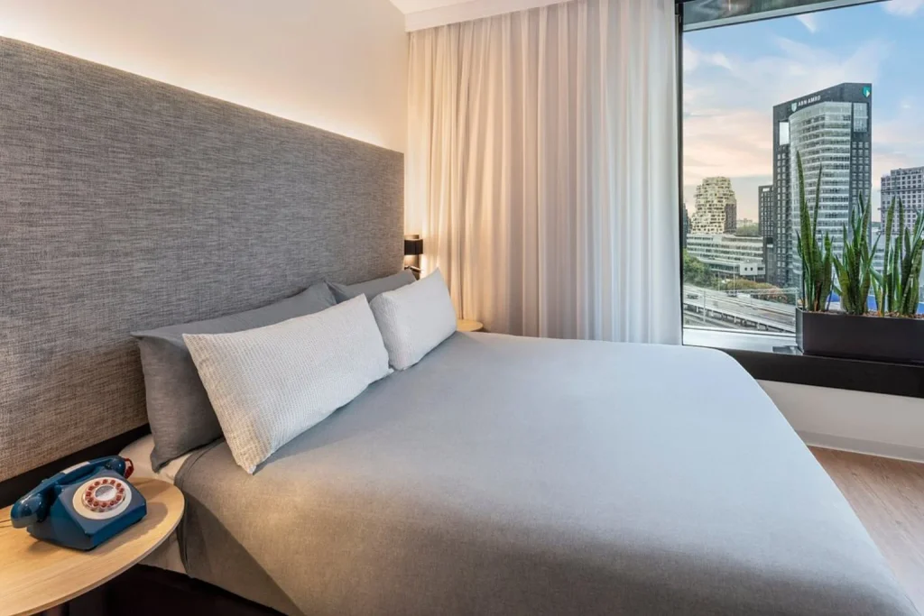 Modern hotel room with king-size bed and panoramic city view at INNSiDE by Meliá Amsterdam, Amsterdam