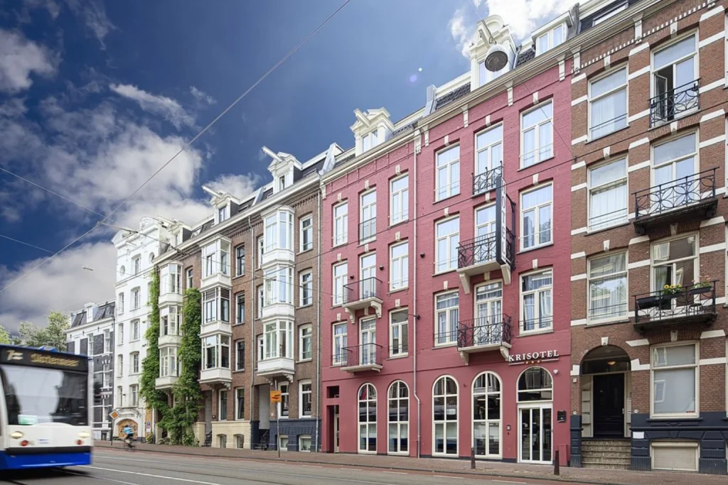 Distinctive red-brick facade surrounded by traditional architecture on a central Amsterdam street at Krisotel Amsterdam.