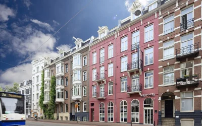 Historic red-brick hotel facade along a lively Amsterdam street at Krisotel Amsterdam