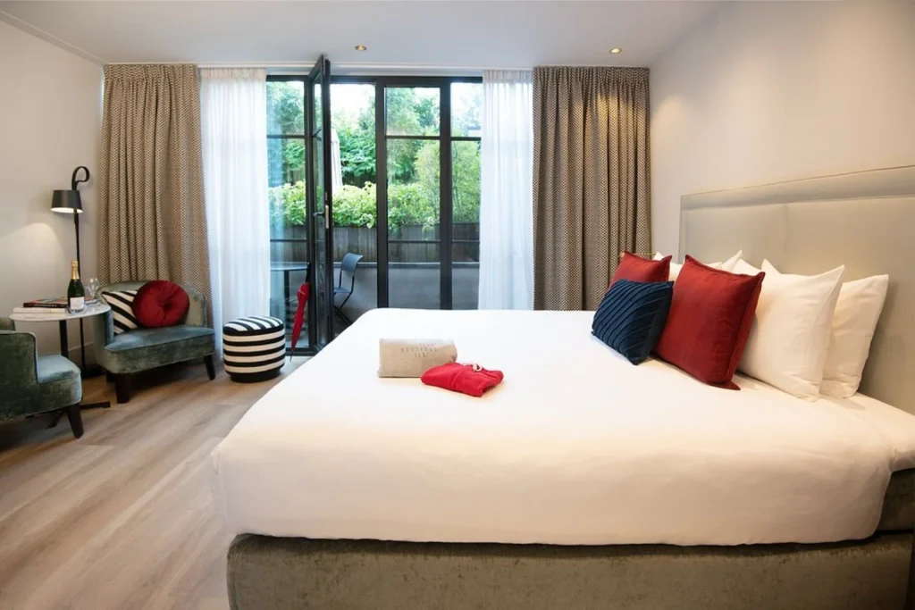 Elegant boutique hotel room with king bed and private terrace at Maison ELLE Amsterdam, Amsterdam
