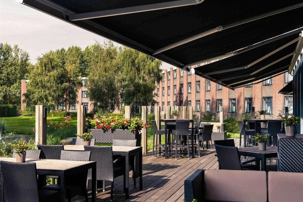 Outdoor garden terrace with tables, seating and flowers at Mercure Hotel Amsterdam West, Amsterdam