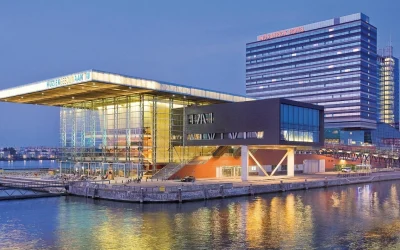 Waterfront view of Mövenpick Hotel Amsterdam City Centre beside the Muziekgebouw in Amsterdam