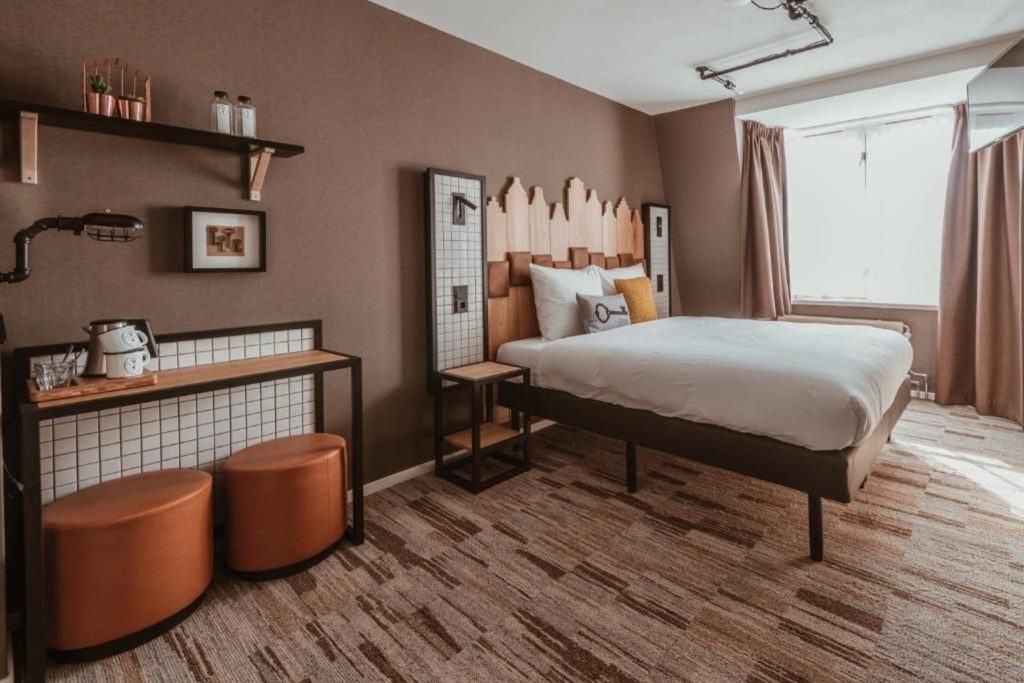 Stylish boutique hotel room featuring a comfortable double bed, warm contemporary décor and distinctive Dutch design details at Mr. Jordaan in Amsterdam.