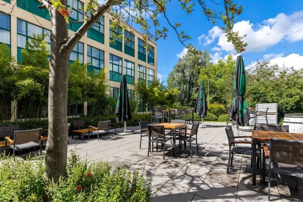Relaxing garden terrace with outdoor seating surrounded by greenery at NH Amsterdam Noord