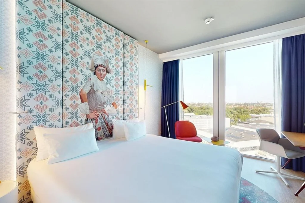 Stylish modern hotel room with floor-to-ceiling windows and colorful artistic décor at nhow Amsterdam RAI, Amsterdam