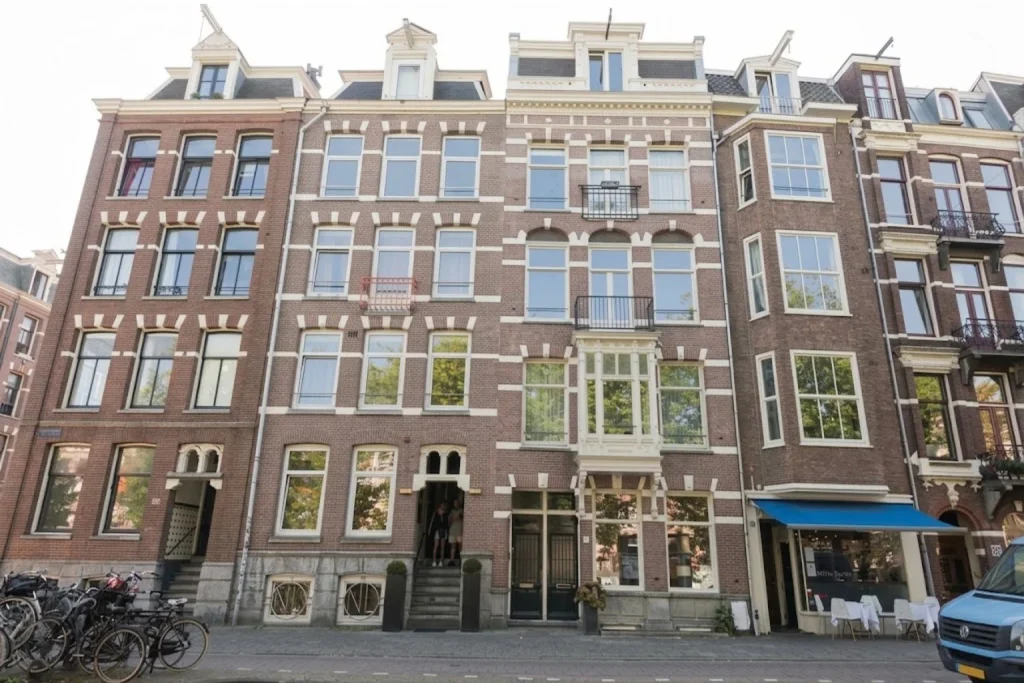 Traditional Amsterdam townhouse façade with tall windows and classic brick architecture at NL Hotel District Leidseplein, Amsterdam, Netherlands