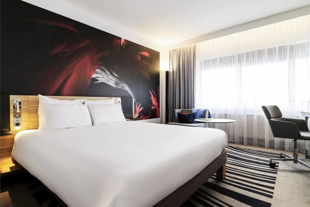 Spacious contemporary guest room with stylish décor, comfortable seating and a dedicated workspace at Novotel Amsterdam City, Amsterdam
