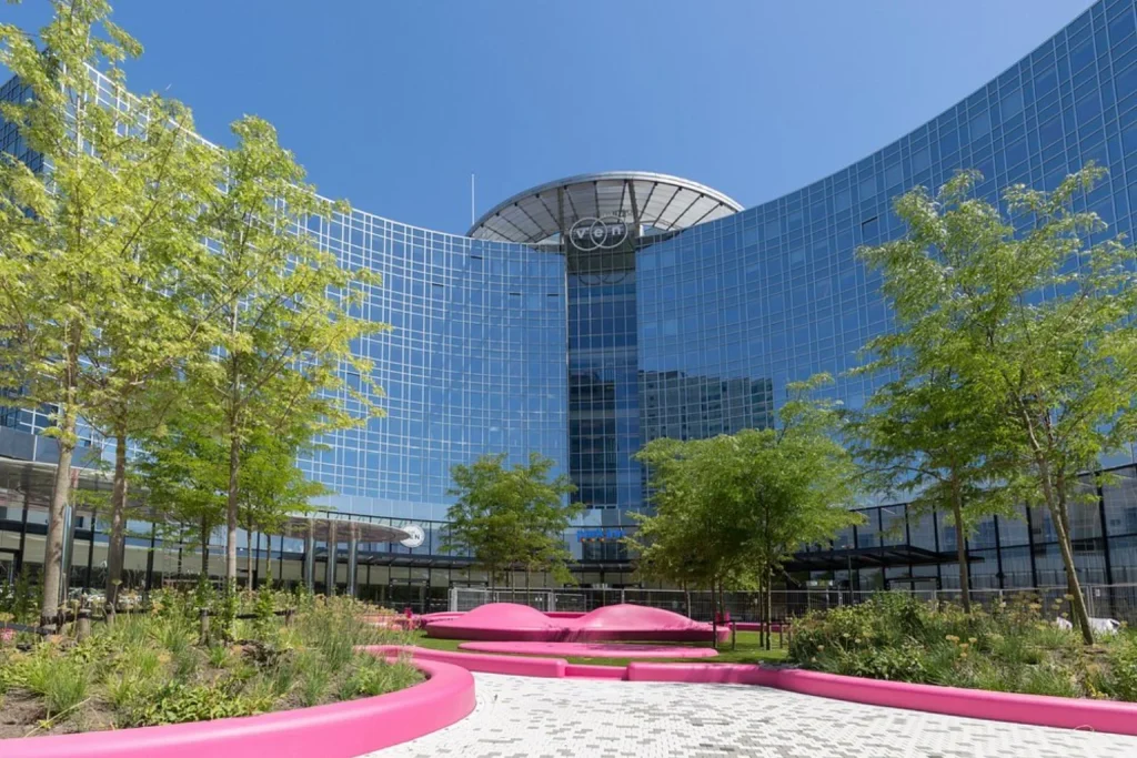 Modern curved glass hotel exterior with landscaped gardens at Park Inn by Radisson Amsterdam City West, Amsterdam