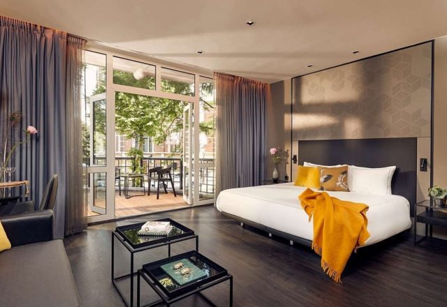 Contemporary guest room with a king bed, elegant seating area and private balcony at Park Plaza Vondelpark, Amsterdam