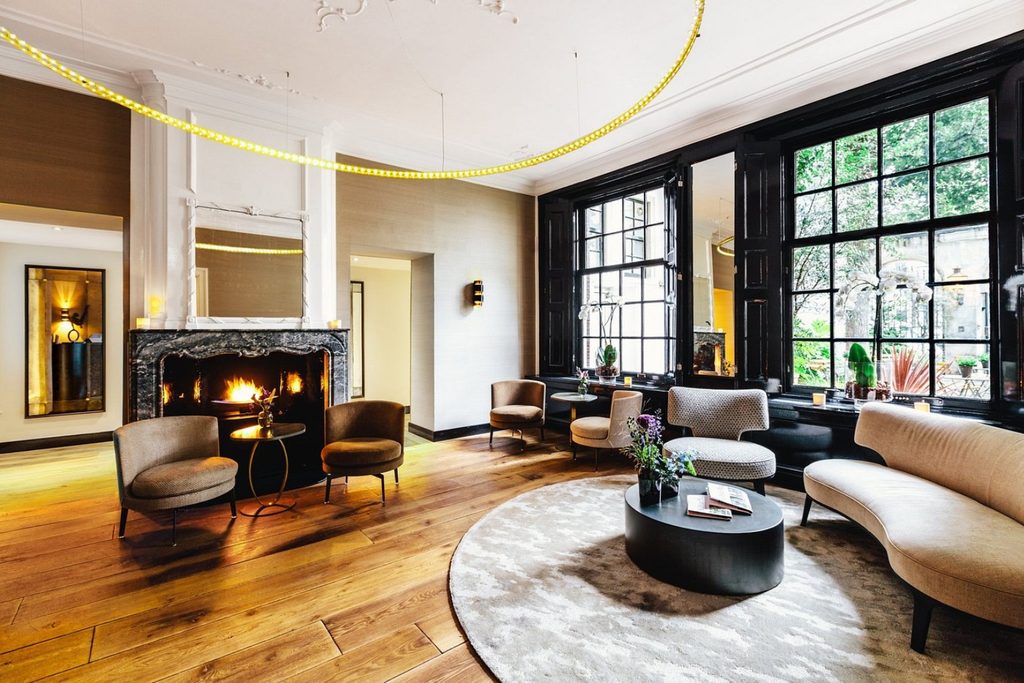 Luxury boutique hotel lounge with fireplace and elegant contemporary seating at The Dylan Amsterdam