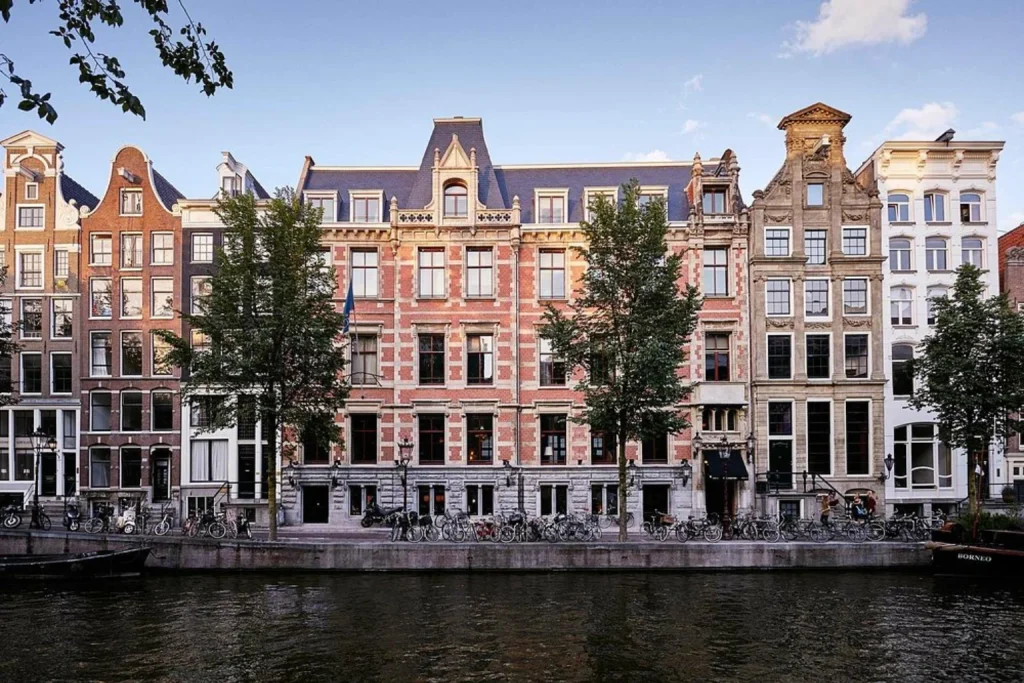 Elegant historic façades overlooking an Amsterdam canal with rows of bicycles at The Hoxton, Amsterdam West, Amsterdam