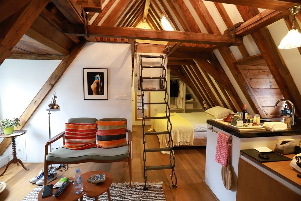 Characterful attic guest room featuring original exposed timber beams, a double bed, vintage-style seating and private kitchenette at The Weavery Boutique B&B, Amsterdam