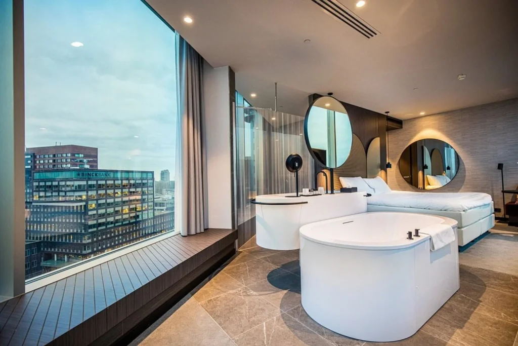Luxury hotel room with freestanding bathtub, king bed, floor-to-ceiling windows and Amsterdam Zuidas views at Van der Valk Hotel Amsterdam Zuidas in Amsterdam