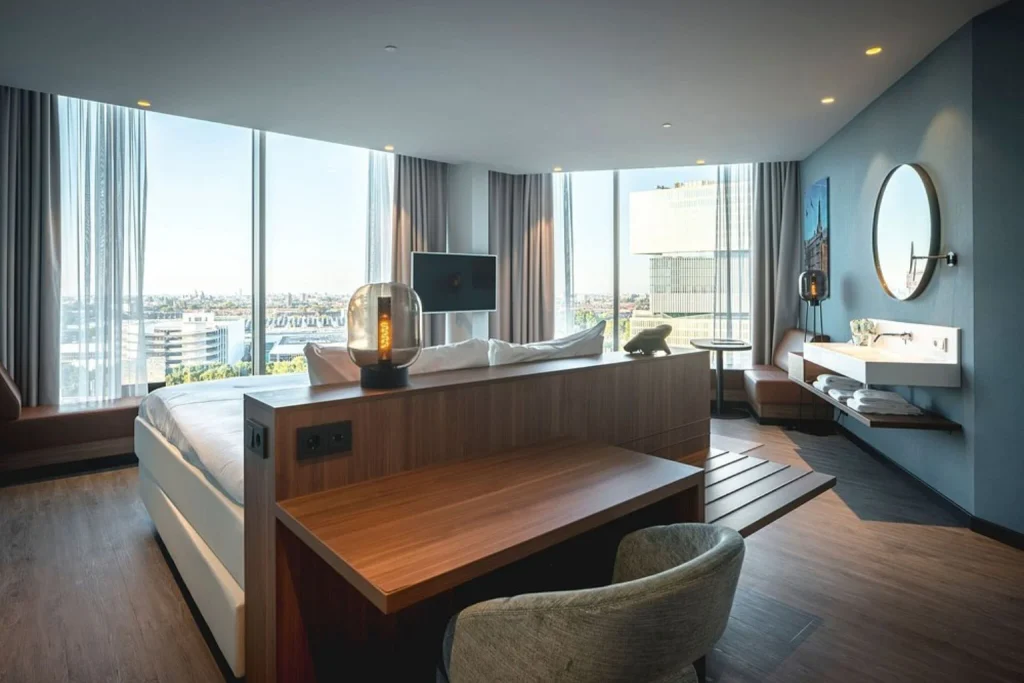 Spacious modern guest room with floor-to-ceiling windows and panoramic city views at Van der Valk Hotel Amsterdam Zuidas, Amsterdam